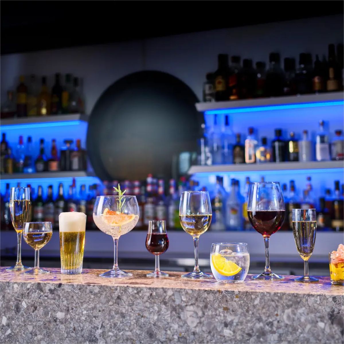 Filled Cosy Moments glass 34 cl. with printed logo placed in an atmospheric setting on bar.