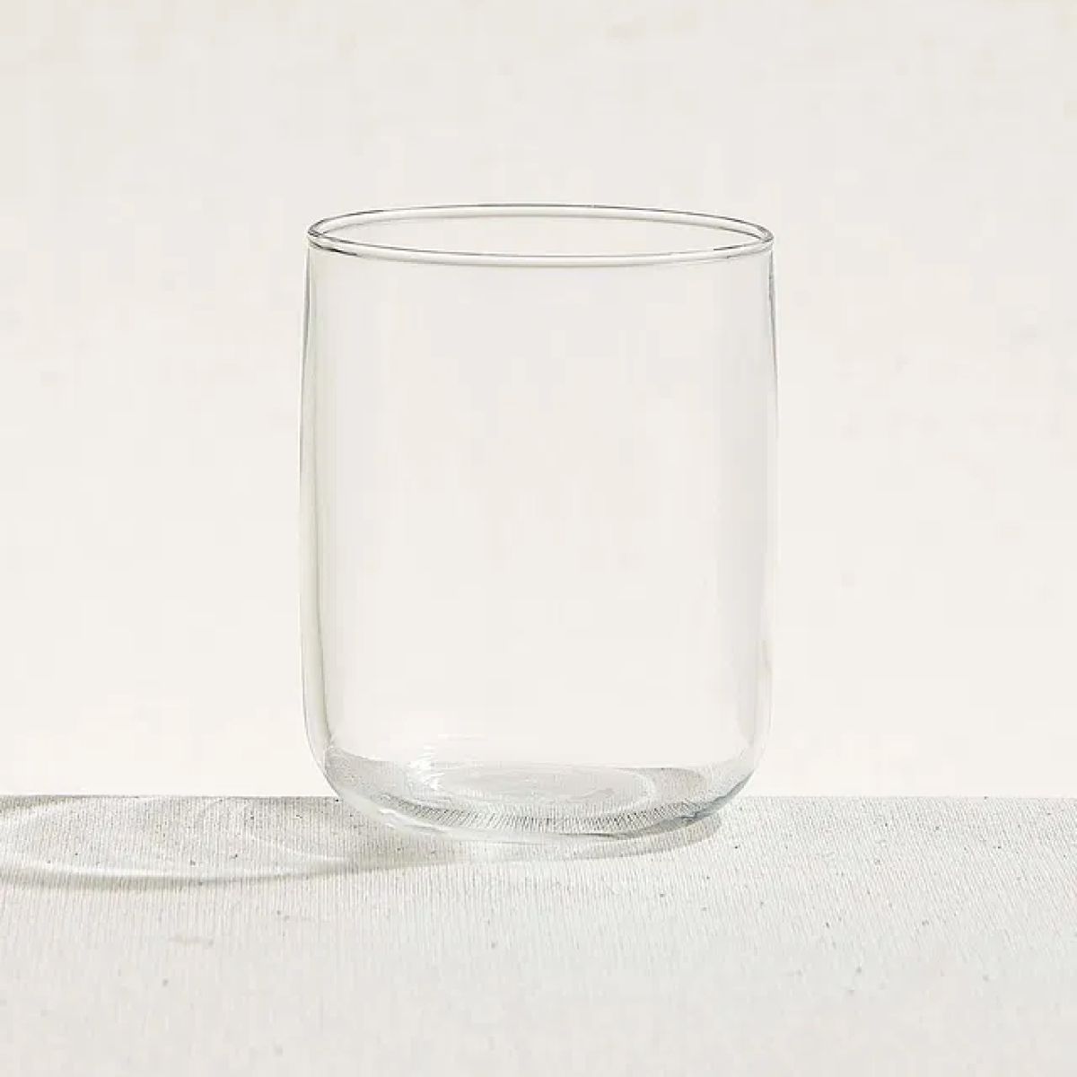 Filled Iconic Tumbler 27 cl. glass with clear drink against white background in studio shot.