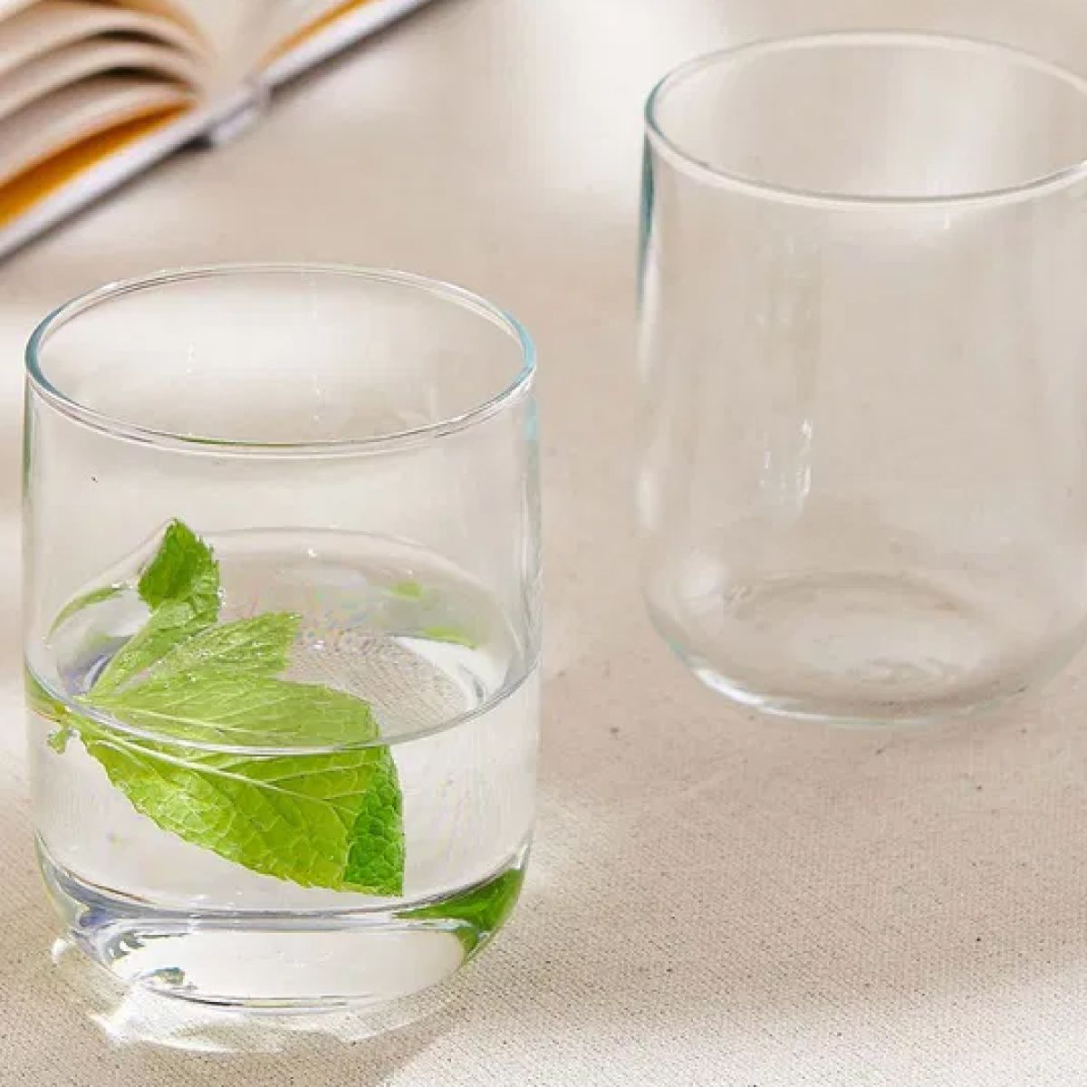 Iconic Tumbler 27 cl. glass with drink and printed logo, placed in modern ambient space.