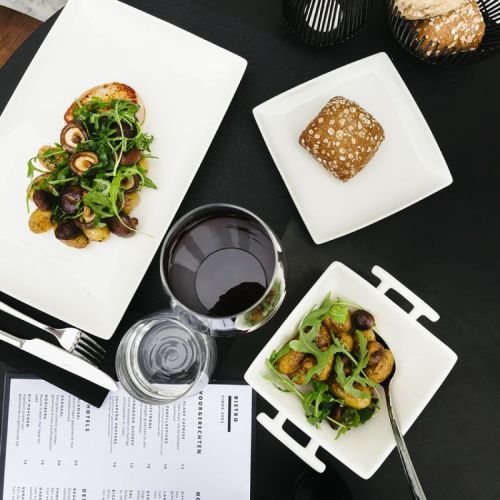 Square Squito plate 10 cm porcelain with filling presented in atmospheric space.