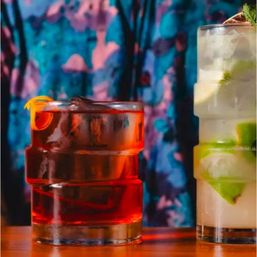 The Glitch tumbler glass 35.5 cl. filled with drinks, placed in atmospheric setting.