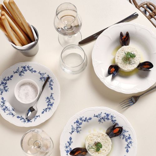 Gedekt bord Retro 24 cm porselein met inhoud en bedrukt logo, gepresenteerd in sfeervolle setting.