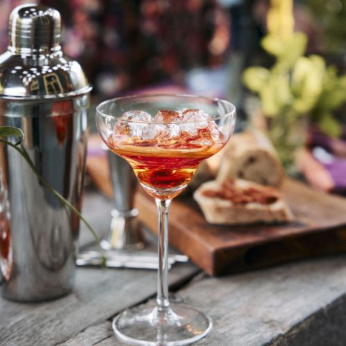 Cocktailglas met vulling gepresenteerd in een sfeervolle omgeving. Cocktailglas met vulling gepresenteerd in een sfeervolle omgeving.