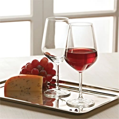 Filled Allegra wine glass with visible logo in atmospheric setting with soft light and plain background. Filled Allegra wine glass with visible logo in atmospheric setting with soft light and plain background.