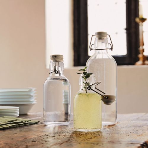 Emilia Fles 0,5 liter met logo op tafel in een warm verlichte omgeving. Emilia Fles 0,5 liter met logo op tafel in een warm verlichte omgeving.