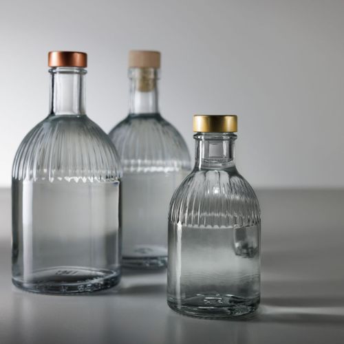 Fles Florence 0,2 liter glas gevuld met drank, geplaatst in sfeerruimte met natuurlijke setting.