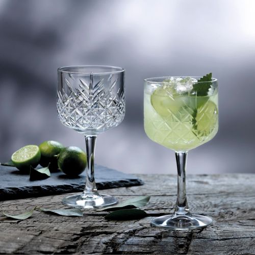 Filled Timeless Gin-Tonic glass 55 cl. presented in atmospheric setting on the table.