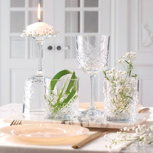 Filled Timeless wine glass placed in atmospheric setting with natural lighting.