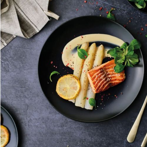Porcelain Venus plate 26 cm with logo and filling, attractively presented in dining situation.