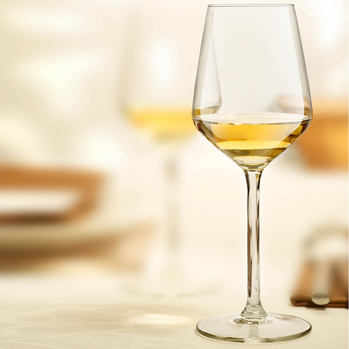 Carre wine glass 29 cl. with liquor and printed logo, placed in an atmospheric setting.